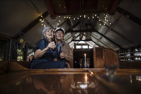 Happy senior couple having a drink on a boat in boathouse stock photo