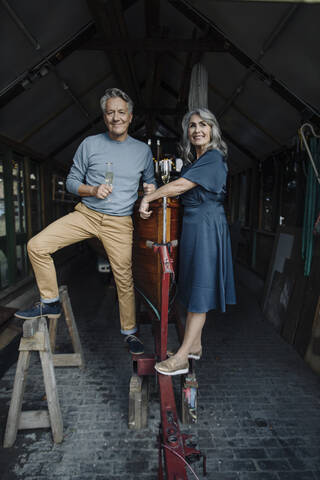 Älteres Paar in einem Bootshaus mit einem Glas Champagner, lizenzfreies Stockfoto