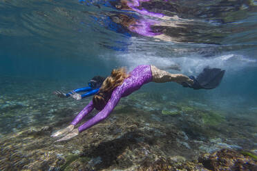 Two young women snorkeling in Nusa Penida island, Bali, Indonesia - KNTF03768