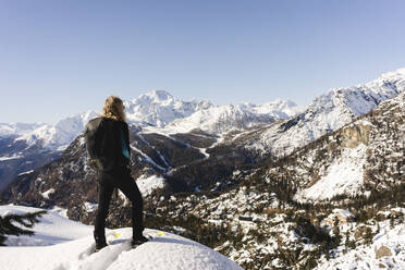 Frau, die mit Schneeschuhen auf einem Aussichtspunkt steht, Valmalenco, Italien - MRAF00465