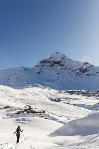 Frau geht mit Schneeschuhen im Neuschnee in den Bergen, Valmalenco, Italien, lizenzfreies Stockfoto