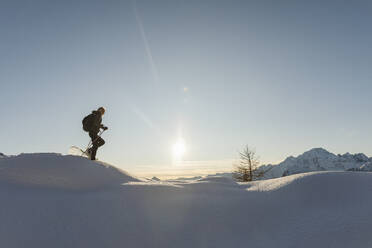Frau geht mit Schneeschuhen im Neuschnee in den Bergen, Valmalenco, Italien - MRAF00482