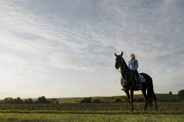 Frau auf Pferd auf einem Feld auf dem Lande - JOSF04119