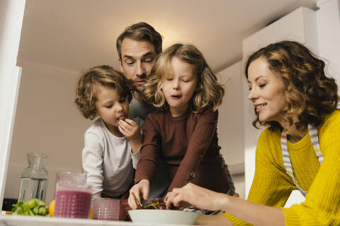 Familie isst Weintrauben in der Küche, lizenzfreies Stockfoto