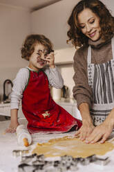 Mother and daughter preparing Christmas cookies in kitchen - MFF04945