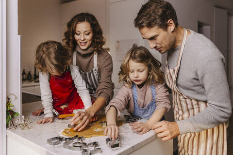 Familie bereitet in der Küche Weihnachtsplätzchen zu, lizenzfreies Stockfoto