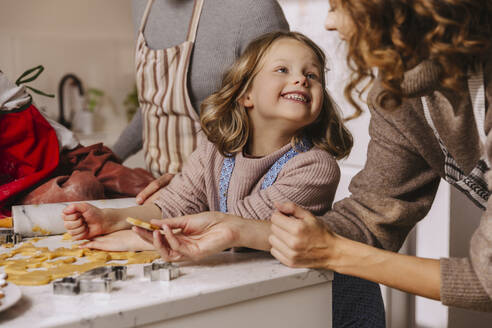 Glückliche Familie bei der Zubereitung von Weihnachtsplätzchen in der Küche - MFF04955