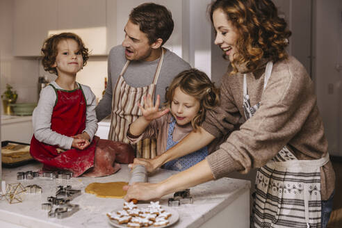 Familie bereitet in der Küche Weihnachtsplätzchen zu - MFF04956