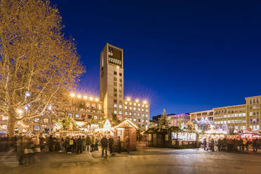 Germany, Baden-Wurttemberg, Stuttgart, Christmas market stalls and town hall at dusk - WDF05623