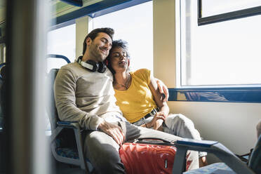 Junges Paar mit geschlossenen Augen entspannt sich in einem Zug - UUF19790