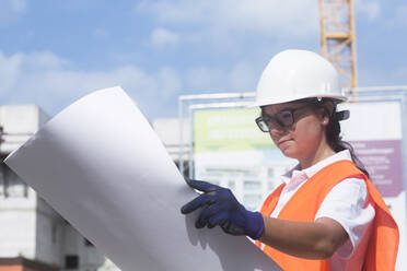 Bauingenieurin betrachtet einen Bauplan - SGF02560