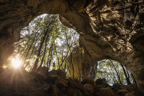 Woman at the exit of a cave in backlight, Finale Ligure, Liguria, Italy - MSUF00091