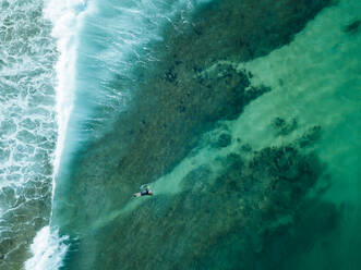 Indonesien, Sumbawa, Luftaufnahme eines Surfers auf dem Meer - KNTF03798