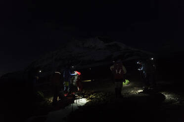Bergsteiger mit Stirnlampen bei der Vorbereitung auf die Nacht, Dhaulagiri Circuit Trek, Himalaya, Nepal - ALRF01669