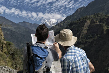 Two hikers reading map at Muri, Dhaulagiri Circuit Trek, Himalaya, Nepal - ALRF01686