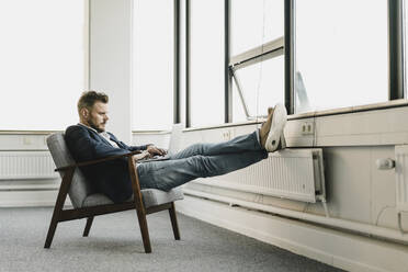 Geschäftsmann mit Laptop im Coworking Space - KNSF06992