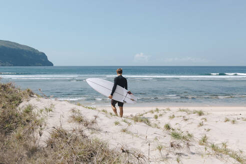 Mann mit Surfbrett am Strand, Sumbawa, Indonesien - KNTF03807