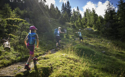 Mother with two children hiking in alpine scenery, Passeier Valley, South Tyrol, Italy - DIKF00314