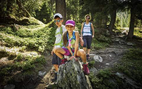 Porträt einer Mutter mit zwei Kindern beim Wandern in alpiner Landschaft, Passeiertal, Südtirol, Italien, lizenzfreies Stockfoto