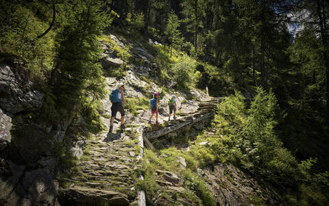 Mother with two children hiking in alpine scenery, Passeier Valley, South Tyrol, Italy stock photo