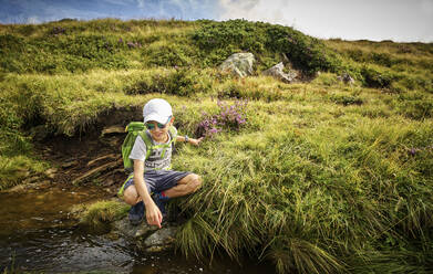 Junge hockt an einem Bergbach, Passeiertal, Südtirol, Italien - DIKF00330