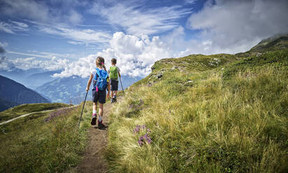 Boy and girl hiking in alpine scenery, Passeier Valley, South Tyrol, Italy - DIKF00334