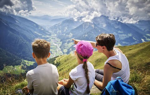 Mutter mit zwei Kindern macht eine Pause vom Wandern in alpiner Landschaft, Passeiertal, Südtirol, Italien, lizenzfreies Stockfoto