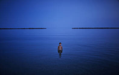 Boy bathing in the sea at night, Italy - DIKF00353