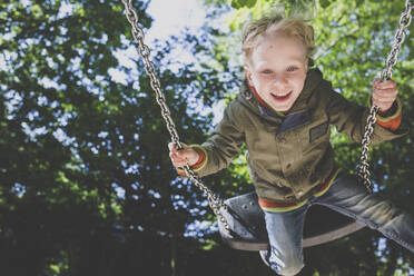 Portrait of happy little boy on a swing - IHF00251