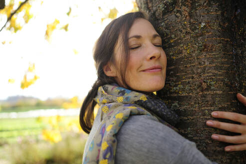 Portrait of woman tree hugging - ECPF00799