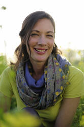 Portrait of woman in the nature, wearing green t-shirt and scarf - ECPF00815