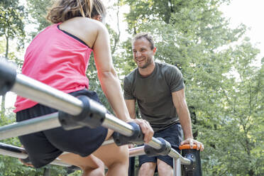 Mann und Frau trainieren auf einem Fitnessparcours - FBAF01104