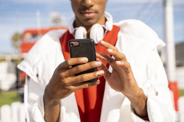 Close-up of young man using smartphone outdoors - AFVF04655