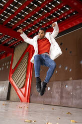 Young man jumping and dancing outdoors - AFVF04665