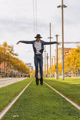 Young man jumping and dancing on tram rails - AFVF04674