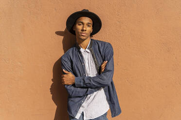 Portrait of stylish young man wearing a hat at a wall - AFVF04685