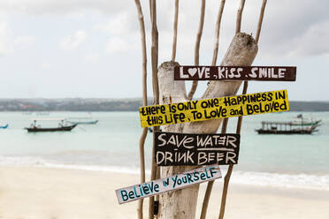 Indonesien, Bali, Jimbaran, Schild mit motivierenden Zitaten am Küstenstrand - KNTF03866
