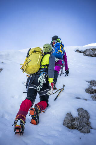Alpinisten beim Aufstieg auf einen verschneiten Berg, Orobie-Alpen, Lecco, Italien, lizenzfreies Stockfoto