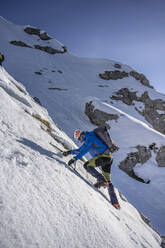 Alpinist beim Aufstieg auf einen verschneiten Berg, Orobie Alpen, Lecco, Italien - MCVF00149