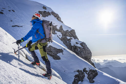 Alpinist beim Aufstieg auf einen verschneiten Berg, Orobie Alpen, Lecco, Italien - MCVF00150