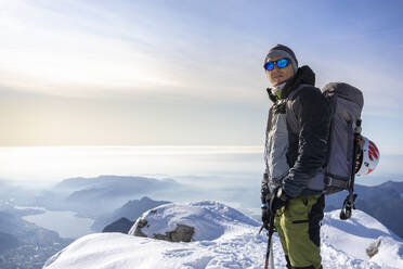 Porträt eines Alpinisten auf einem verschneiten Berggipfel, Orobie-Alpen, Lecco, Italien - MCVF00155