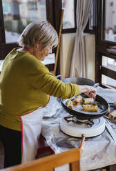 Senior woman preparing Spanish Christmas pastry Pestinos - LJF01210