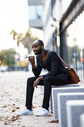 Young businessman using cell phone outdoors - JSRF00691