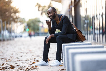 Young businessman using cell phone outdoors - JSRF00692