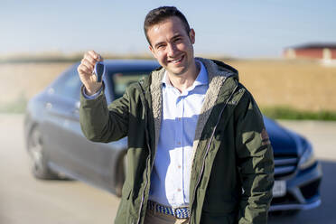 Portrait of smiling young businessman holding car key - CJMF00225