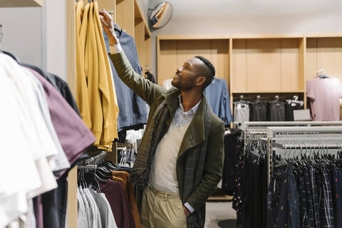 Stilvoller Mann beim Einkaufen in einem Bekleidungsgeschäft, lizenzfreies Stockfoto