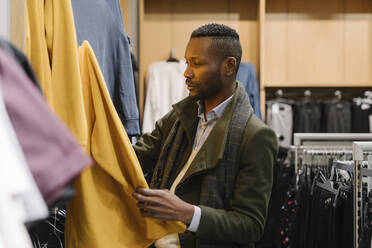 Stylish man shopping in a clothes store - AHSF01643