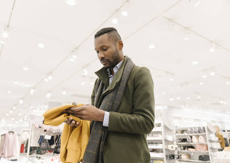 Stilvoller Mann beim Einkaufen in einem Bekleidungsgeschäft - AHSF01646