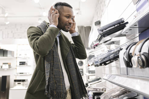 Man trying headphones in a store - AHSF01647