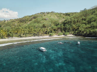 Indonesien, Bali, Boote schwimmen im Wasser an der Küste der Insel Nusa Penida - KNTF03868